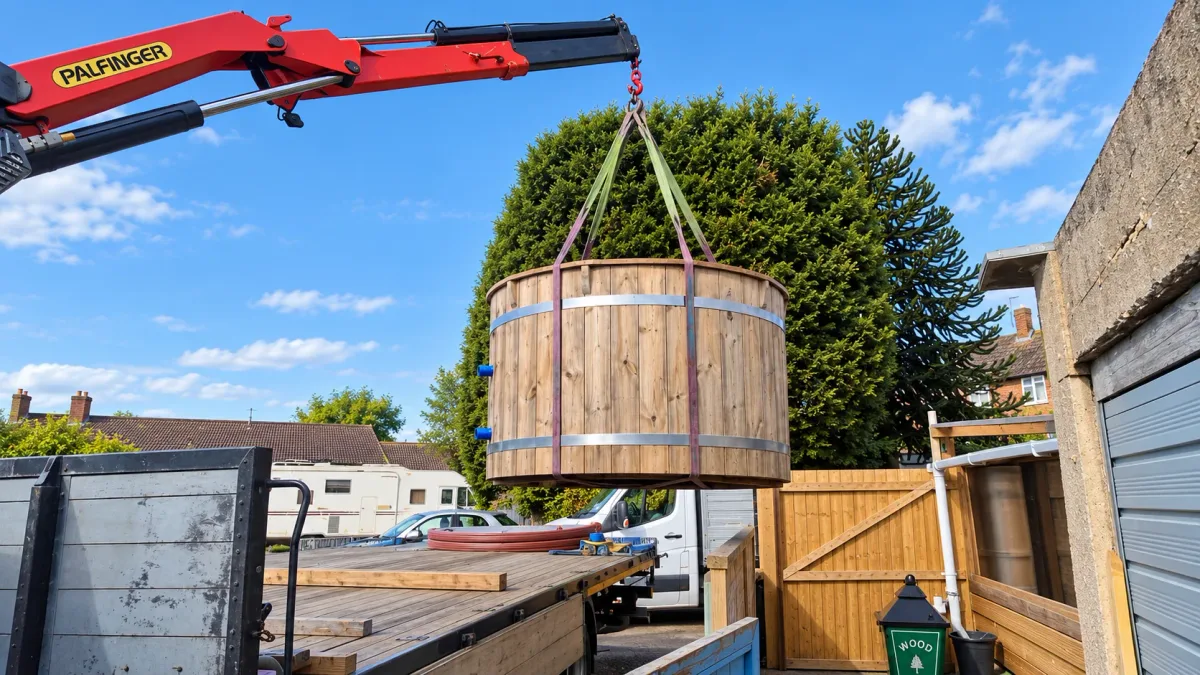 Wooden hot tub lifted off a lorry by a HIAB crane